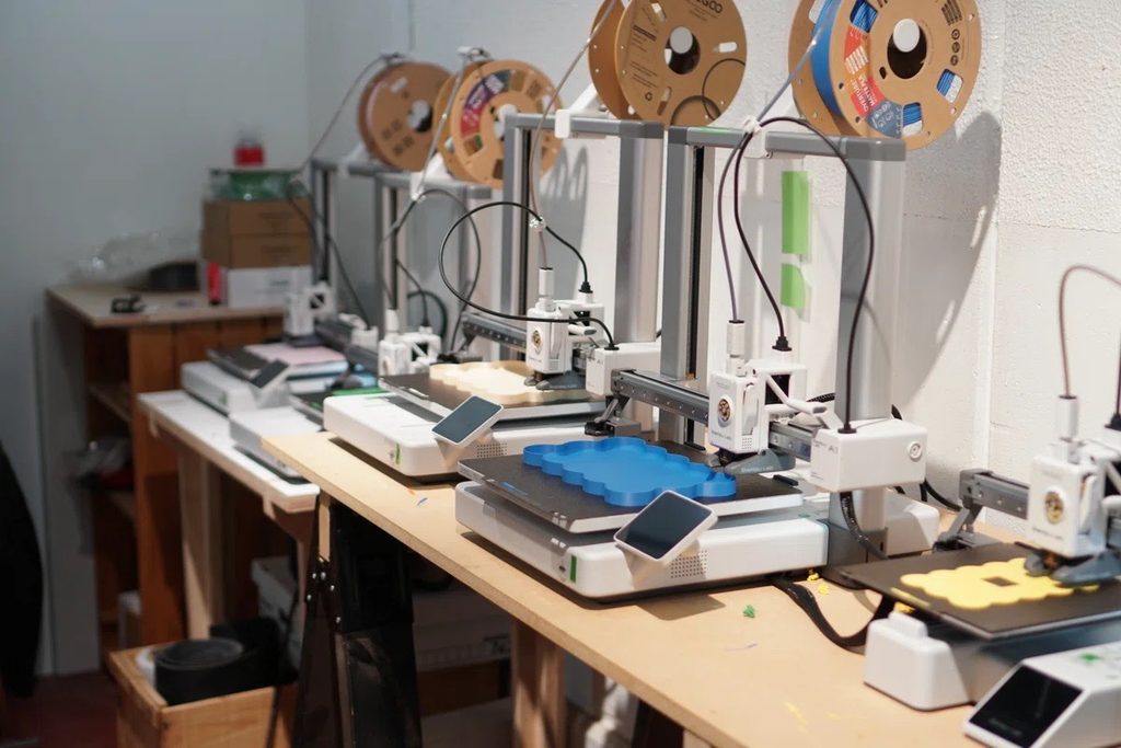 作業台に並んで稼働する、何台もの3Dプリンター